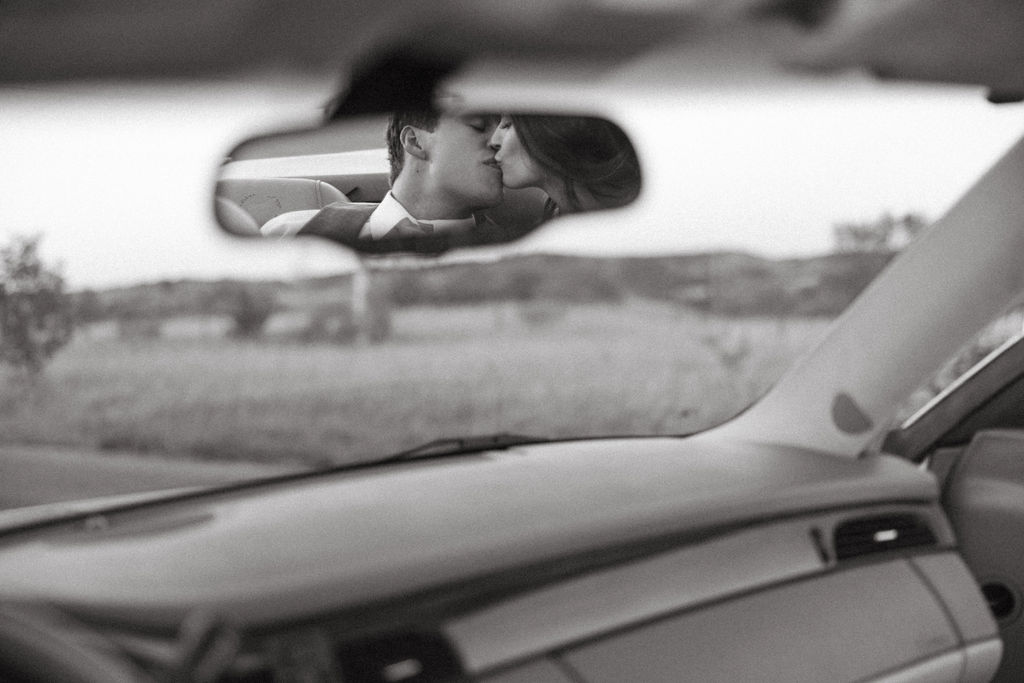 couple kissing in rearview mirror